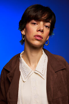 Woman poses with blue background in studio setting