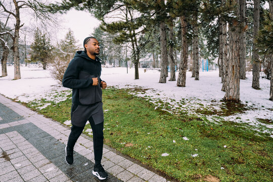 Black Man Jogging on Park Path in Winter