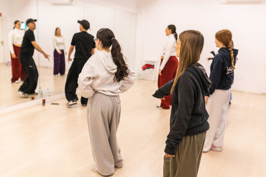 Male instructor teaching urban dance to teenagers in studio