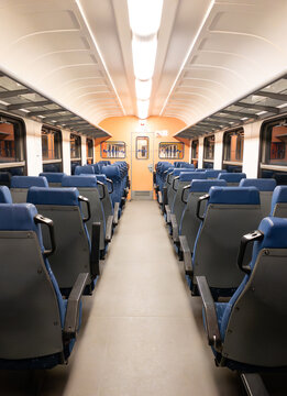 An empty railway car with rows of empty seats. 