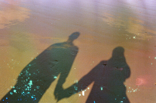 Shadow of a couple holding their hands on the beach