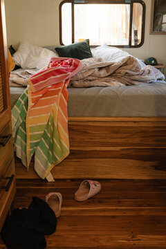 Cozy room with messy bed in a rustic dwelling.