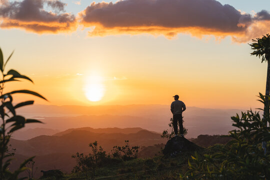 Man enjoying sunset mountain view on hilltop