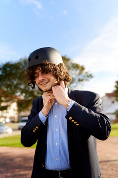 Young man fastening bike helmet for safe commute