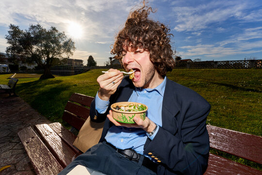 Man eating healthy salad enjoying park lunch