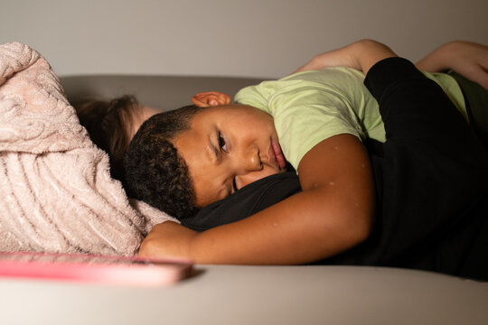 Tired Child Seeking Comfort in Parent&rsquo;s Arms at Home