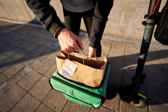 Food delivery rider preparing order on street