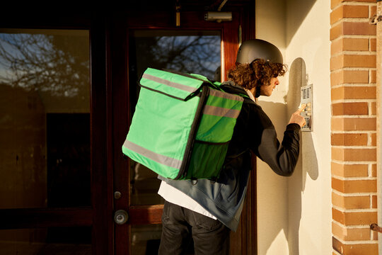 Food delivery courier ringing doorbell delivering order