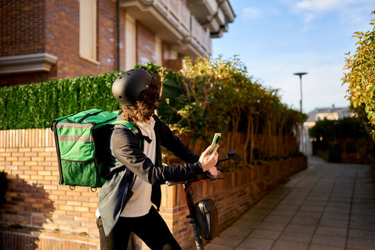 Food delivery rider navigating city using electric scooter