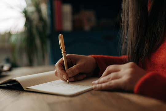 Close Up of Female Hands Writing in Notebook