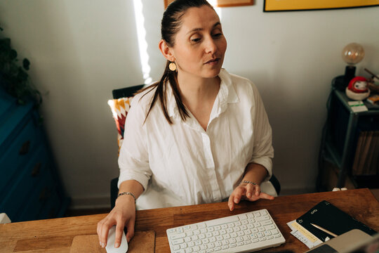 Woman Using Computer Mouse While Working from Home