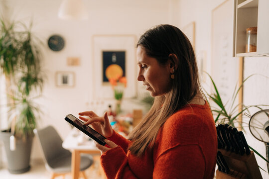 Woman Using Smartphone in Cozy Dining Room