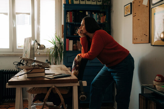 Woman Leaning on Chair Thinking in Home Office
