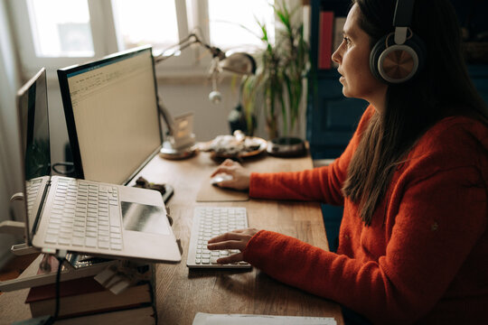 Woman Working at Laptop with Headphones in Home Office