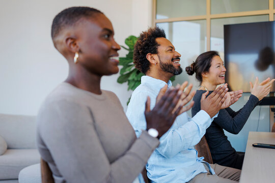 Diverse group applauding success at business meeting