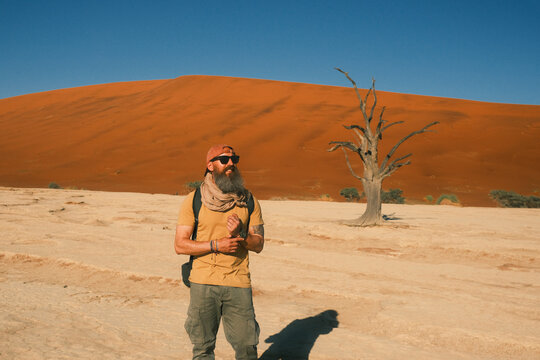 Man standing among dead trees in Deadvlei, Sossusvlei, Namibia