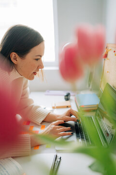 Woman Working at Laptop with Flowers in Foreground