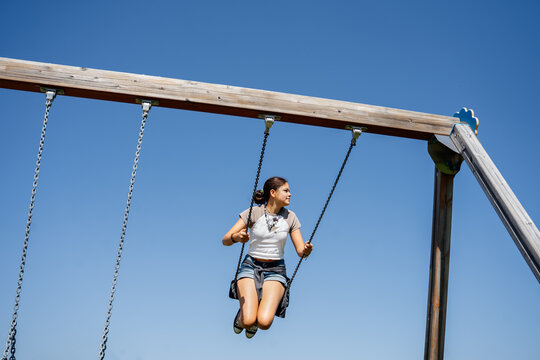 Girl on a swing on a bright summer day. 
