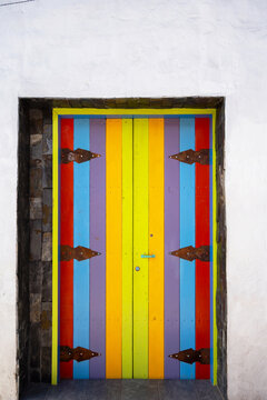 Striped Wooden Door With Rustic Iron Hinge In Guatape