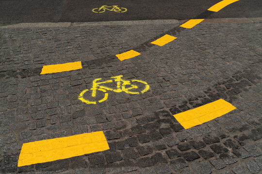 Yellow Bicycle Lane Marking on Cobblestone Street