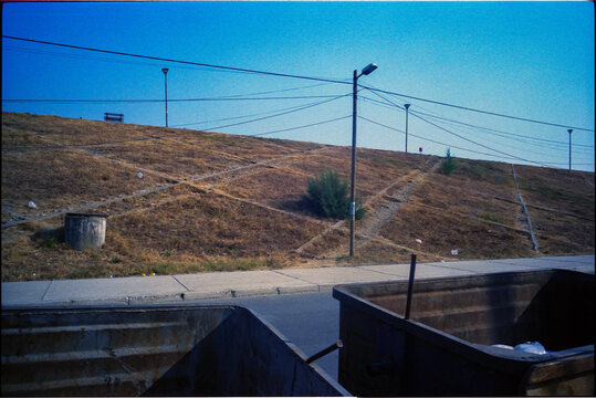 View of a hill with streetlights and power cables