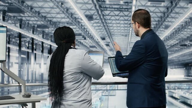 Brainstorming, microelectronics and businesspeople in smart factory developing technology roadmaps. Upgrading semiconductor, devices and teamworking employees using engineering tech software, camera B