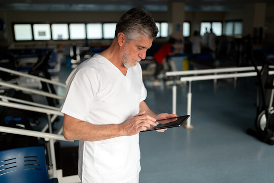 Physiotherapist using digital tablet managing patient records