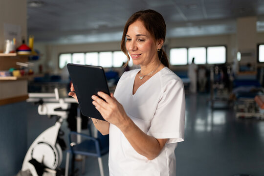 Female physiotherapist using tablet in rehabilitation center