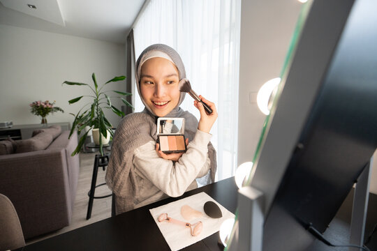 Muslim Make up Influencer Applying Blush Looking At Mirror 