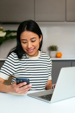 Close-Up of Businesswoman Using Smartphone While Working on Laptop
