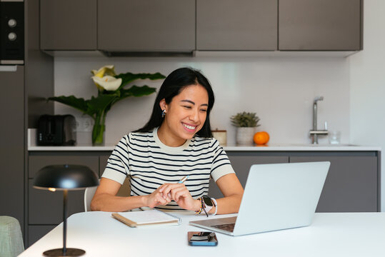 Smiling Young Businesswoman Working from Home with Laptop