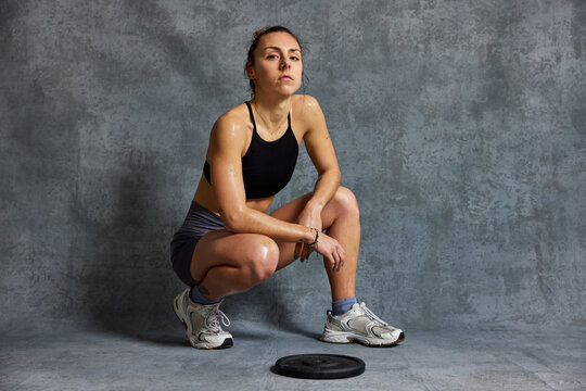 Woman exercises in a gym and shows strength and determination