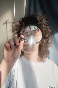 Holding a magnifying glass while looking through it in sunlight