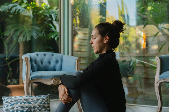 Woman meditating in indoor garden for mindfulness and peace