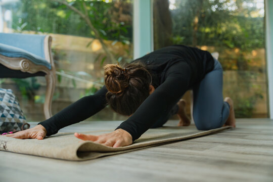 Woman performing yoga stretching in extended child's pose