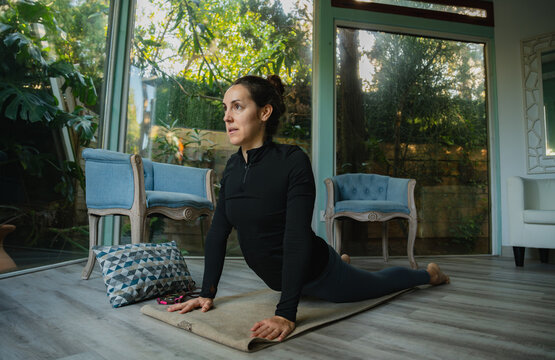 Woman practicing yoga cobra pose for wellness