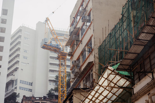 Urban Construction Crane Between City Buildings