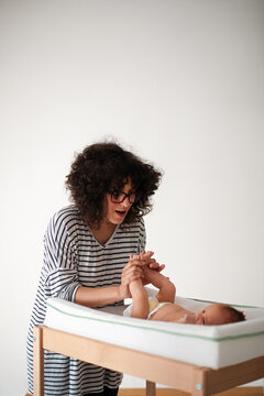 Mother Changing Newborn Baby on Changing Table