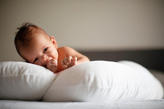 Sleeping Newborn Baby Resting On White Pillow