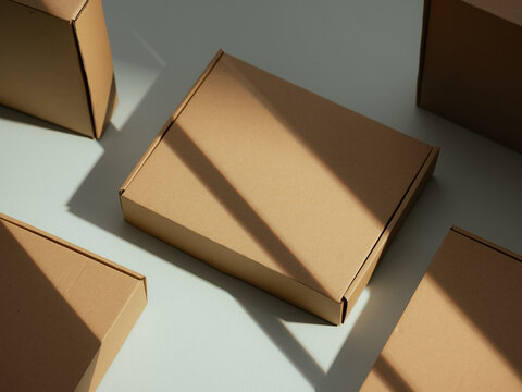 Cardboard boxes arranged on a flat surface with dramatic shadows