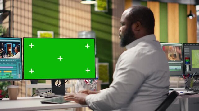 Chroma key with black man videographer refining video content using professional editing software, footage cutting tools and motion graphics panels. Post production adjustments for visual effects.