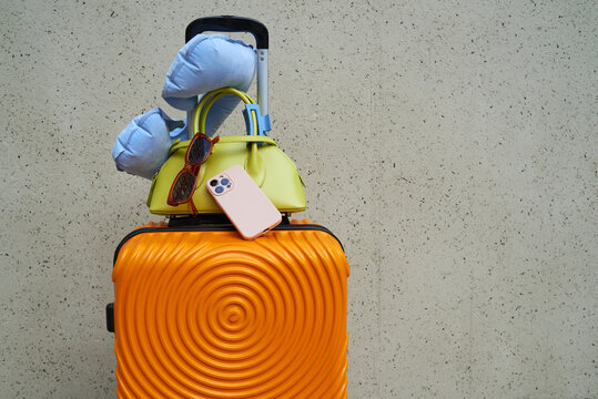 Colorful luggage stacked with travel accessories 
