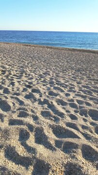 Sandy beach with footsteps near the mediterranean sea