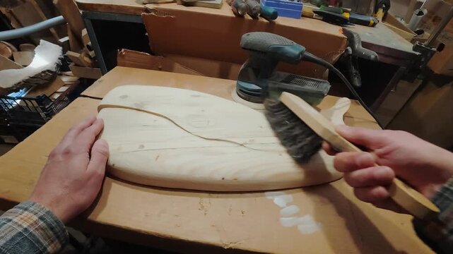 Sanding and cleaning a wooden whale sculpture. Meditative, soul craft in a workshop.