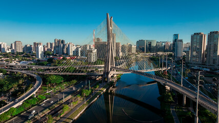 Fototapeta premium Aerial sunset view of Octavio Frias de Oliveira cable-stayed bridge over Pinheiros River, Sao Paulo landmark, Brazil - Drone DJI Mavic 3