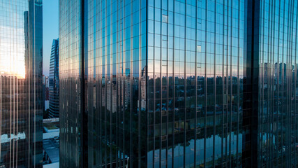Abstract aerial sunset reflection of city skyline on glass curtain wall of a skyscraper in Sao Paulo, Brazil - Drone DJI Mavic 3 © ANDRE
