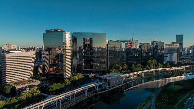 Aerial landscape of Pinheiros River with train station and modern corporate skyscrapers at Berrini district, Sao Paulo, Brazil - Drone DJI Mavic 3