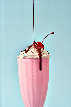 Strawberry milkshake with cream, cherry and  chocolate drip
