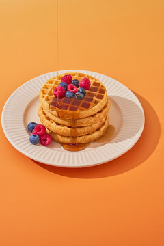 stack of waffles dripping maple syrup