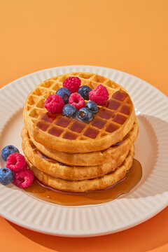 stack of waffles dripping maple syrup